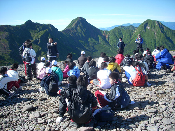 山を背景にした団体登山